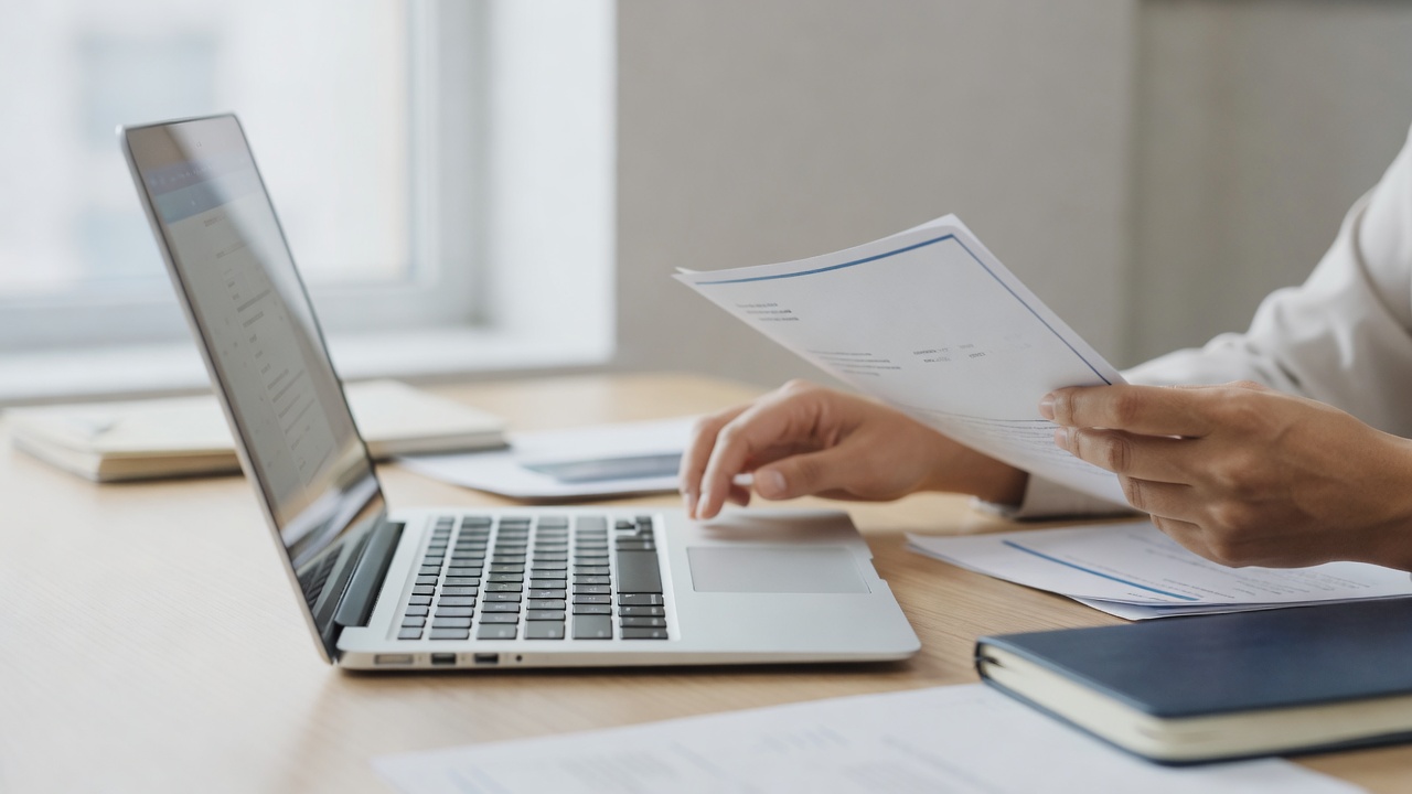 A close-up detail shot related to "What to Do When a Client Disputes an Invoice" — hands, a laptop screen, or paperwork 